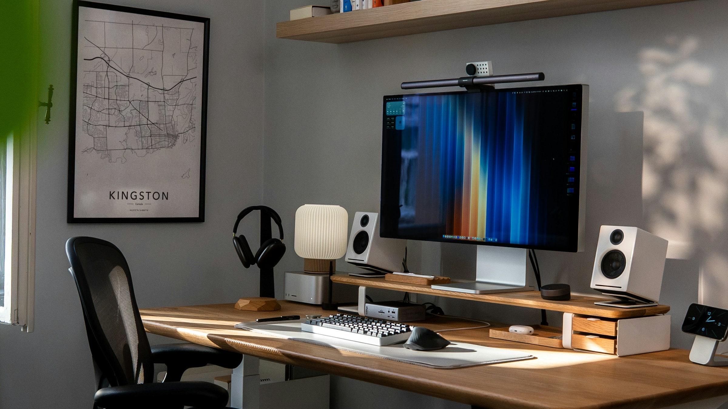 A one-person home office with a desk, monitor and a map of Kingston, Ontario on the wall